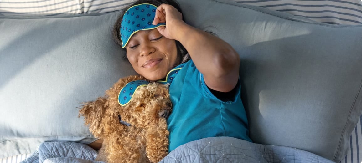 Cane riposa a letto con la sua proprietaria